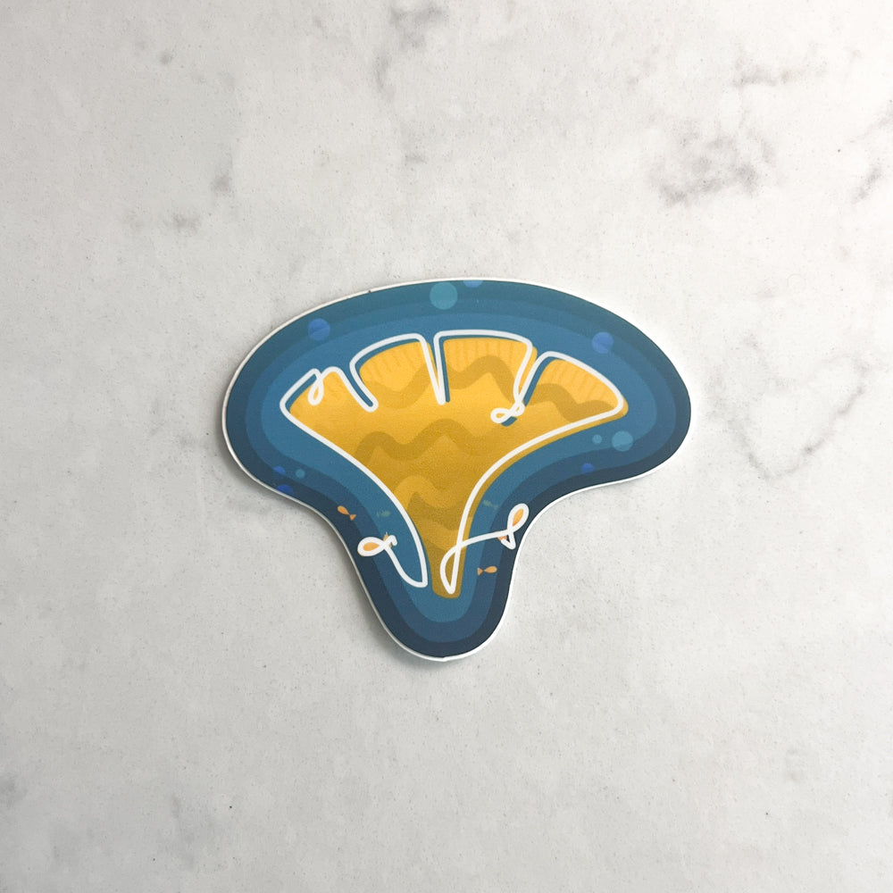 Stickers of yellow coral with fish on a marble surface
