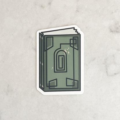 Sticker of a green book with an arch design on a marble background