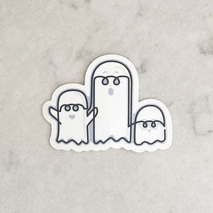 Sticker of three cartoon ghosts on a marble background