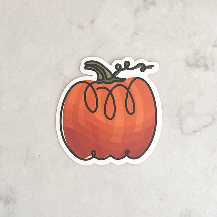 Pumpkin-shaped sticker on a marble surface