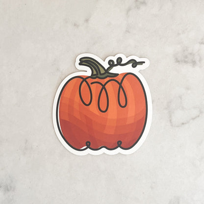 Pumpkin-shaped sticker on a marble surface